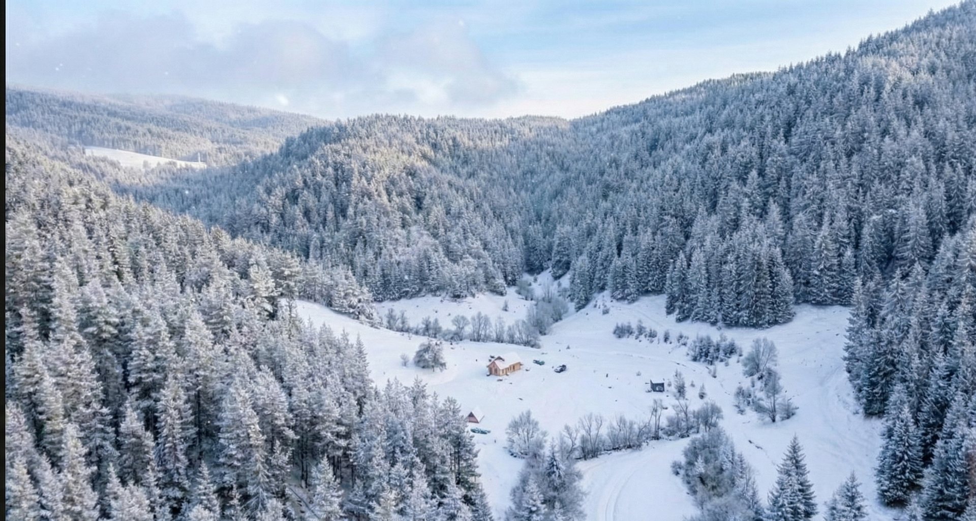 Aerial view of a snow-covered winter valley cabin in Bulgaria's Rhodope Mountains